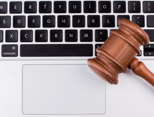 Laptop computer with legal court gavel on keyboard.